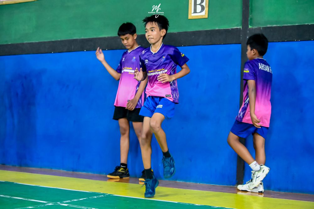 Tiga atlet duduk di bangku pinggir lapangan menunggu giliran