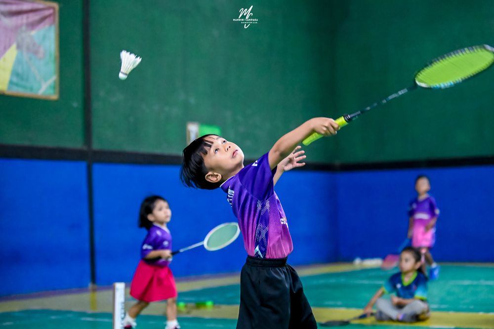 Atlet melompat memukul kok saat latihan